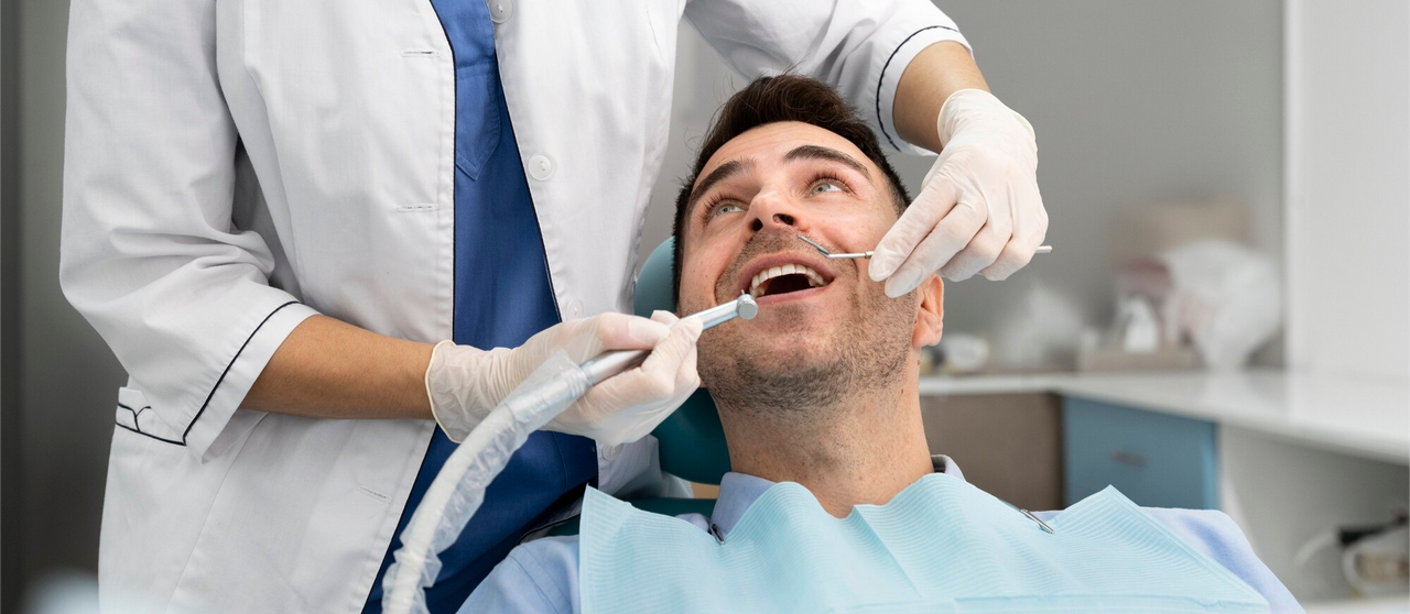 Paciente recibiendo atención dental profesional con herramientas odontológicas en una clínica.