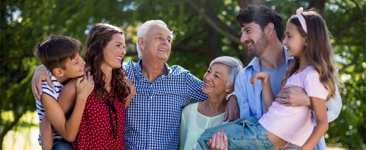 Familia multigeneracional reunida al aire libre, representando el contraste entre baby boomers y millennials en su etapa de jubilación.