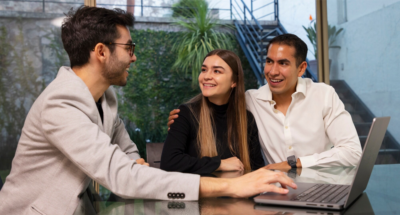 Asesor de seguros discutiendo opciones de seguros de vida y salud con una pareja.