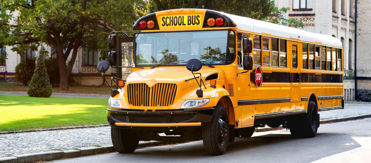 Autobús escolar amarillo estacionado en la calle, listo para transportar estudiantes al colegio.