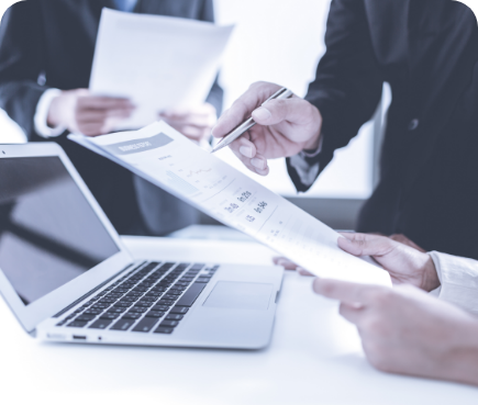 Personas revisando documentos financieros frente a una laptop como parte del proceso de comercialización del producto Priori de Seguros del Pichincha.